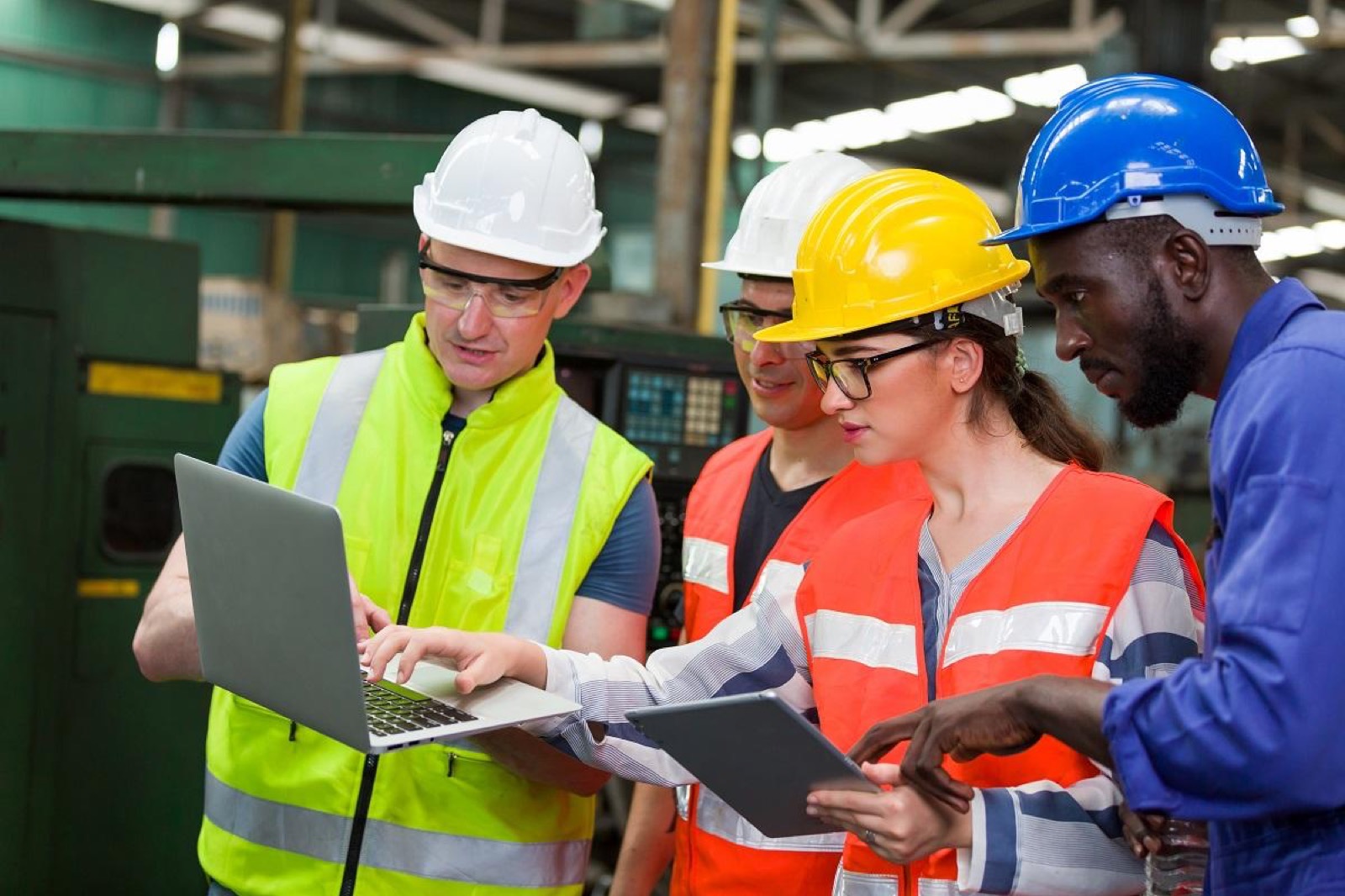 Workers in safety helmets reviewing occupational safety requirements