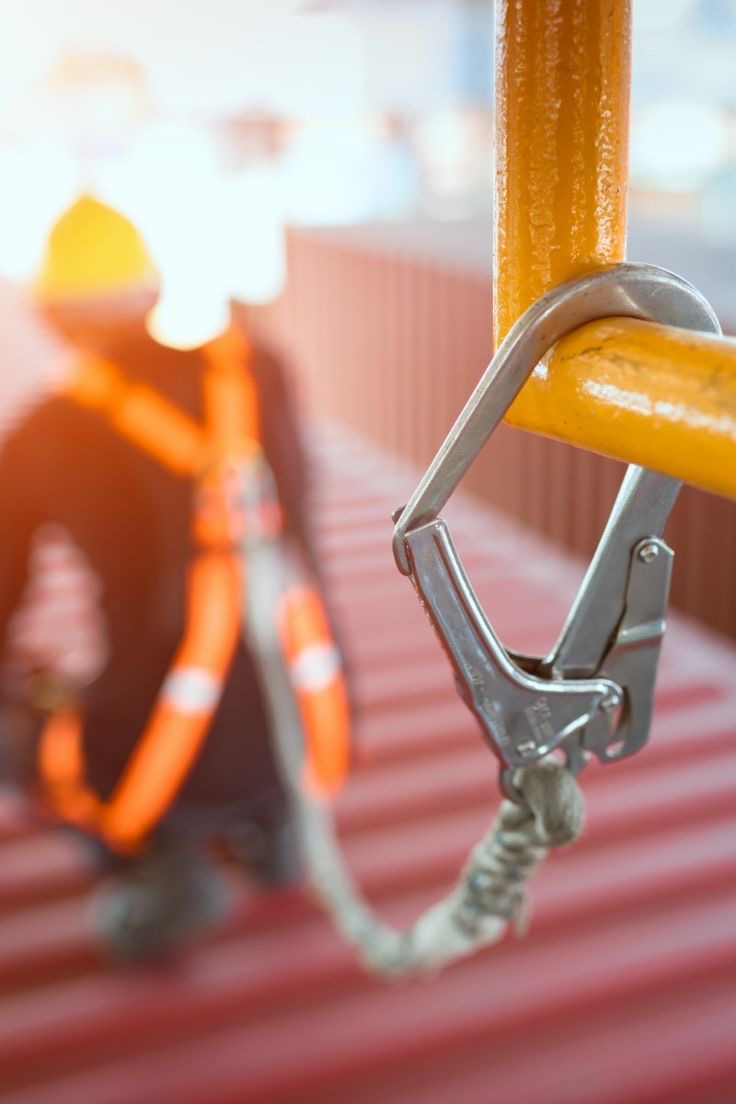 Safety harness lanyard hooked to an anchor point during rope access inspection work at height