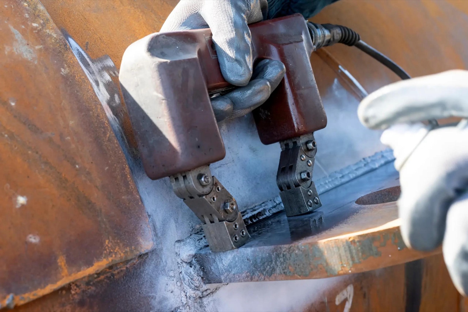 Magnetic particle testing yokes applied to a structural weld during welding inspection
